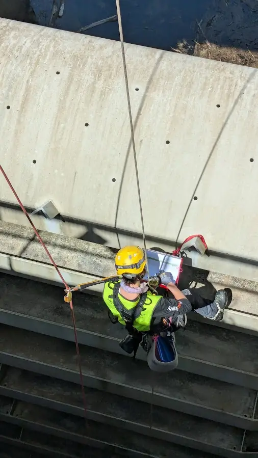 Cordiste inspectant une paroi en béton